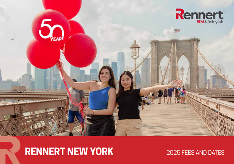 A woman with red balloons stands beside a woman with open arms on the Brooklyn Bridge in NYC