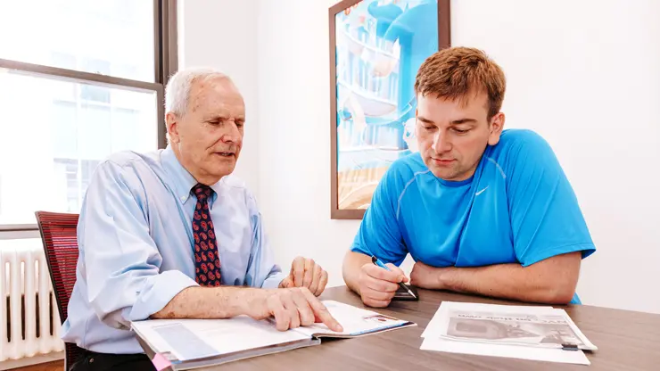 Student receiving one-on-one specialty English instruction with a teacher in a classroom setting.